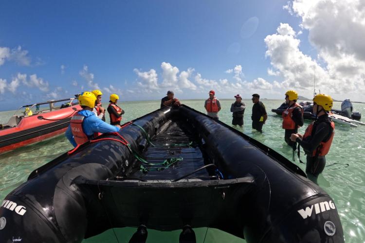 the team prepares in the water around an inflatable boat
