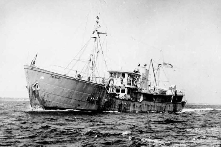 The Albatross III at sea, crew members visible near wheel house. 