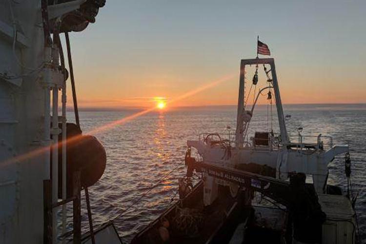 View from a ship on water at sunset. 