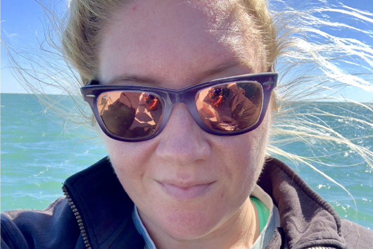 Camille Smith with wind blowing hair and ocean in background
