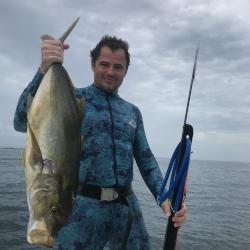 Anthony Mastitski holding a fish and a spear gun.