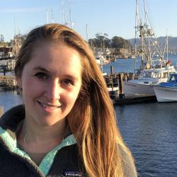 Samantha Werner by the water with boats in the background.
