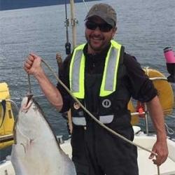 Brian Lieb on a boat posing with caught fish