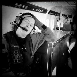Allison Henry on board aircraft with headset and microphone
