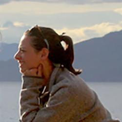 Women watching the water with mountians in the background