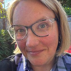 Person wearing glasses with a flannel shirt.