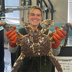 Scientist holding a large crab.