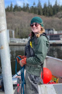 Scientist with glasses in a dusty green coat on a boat