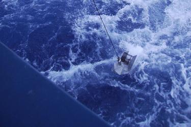 A continuous plankton recorder is lowered into the water for towing behind a commercial vessel.