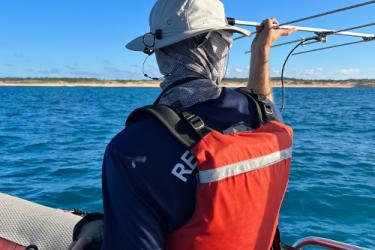 NOAA scientist sight tracking with a Very High Frequency line attached to a entangled humpback whale.