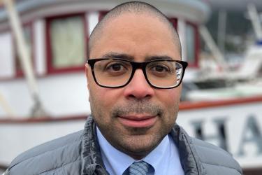 Jamal Moss stands in front of a boat
