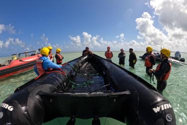 the team prepares in the water around an inflatable boat