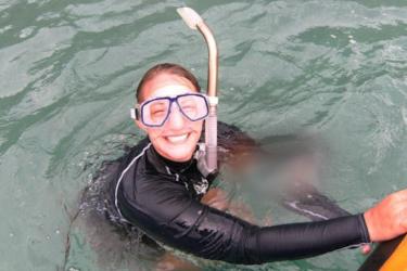 A woman in snorkel gear smiling in the water