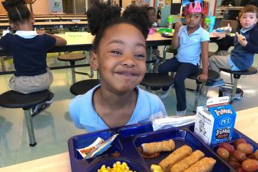 Seafood on a lunch tray with a student from a Greenville County school
