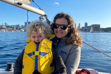 Scientist with child in a safety vest on a boat 