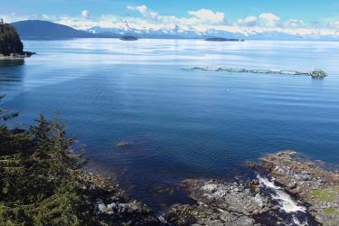 View of harbor with blue water and mountains in the distance