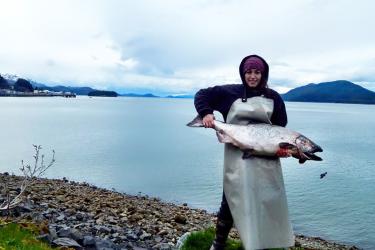 Eyak Tribal Member Tiffany Beedle holding a 35-pound King (Chinook) salmon she processed for the Native Village of Eyak Subsistence program. (Photo: Tiffany Beedle)