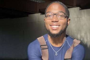 A man with glasses smiling