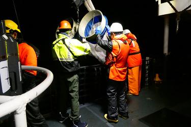 Scientists deploying a net that catches samples from the ocean