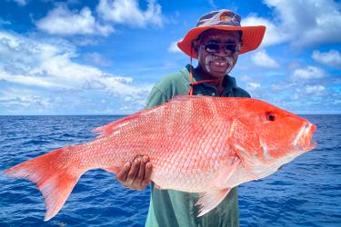 Frank Williams, recreational angler, holds up a red snapper caught in the Gulf of Mexico on board a charter boat