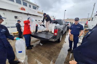 NOAA Fisheries Office of Law Enforcement agent, U.S. Coast Guard officers, and Puerto Rico Department of Natural and Environmental Resources rangers process seized eels in San Juan, Puerto Rico.