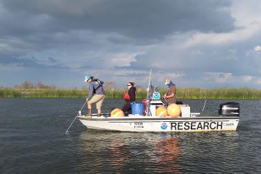 Researchers on a small boat on a river