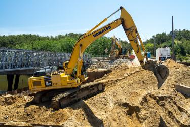 An excavator working at a construction site near the Herring River. 