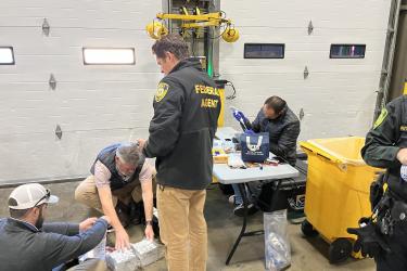 NOAA enforcement staff and a Florida International University scientist perform the first field test of a field forensic device during an enforcement operation in Newark, New Jersey.