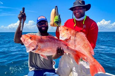 Recreational fishermen hold up two red snapper during a day fishing in the Gulf. Photo courtesy of Captain Grayson Shepard