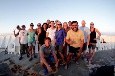 A smiling group of people on a ship deck.
