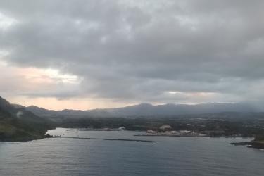 Aerial view of a harbor at sunset with heavy clouds above. 