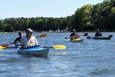 Four kayakers enjoying the water and sunshine.