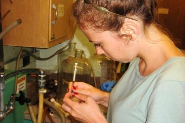 Scientist with hyperdermic needle and clam.