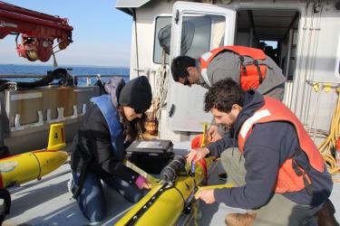 Crew setting up acoustic robots on deck.