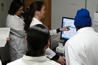 Dr. Frame explains how the HPLC apparatus detects domoic acid in fish and shellfish. Photo: NOAA Fisheries