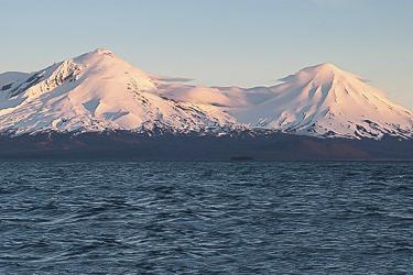Ocean with snow capped mountains in background.