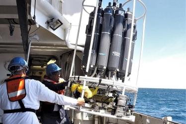 Two scientist pulling the CTD carousel back on board.