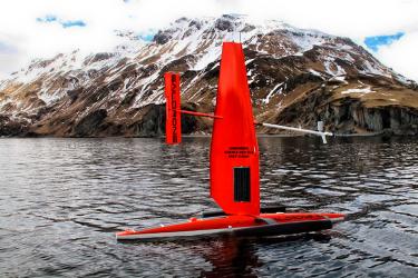 The sail drone in Alaska waters near a snow capped peak. Credit: NOAA Fisheries