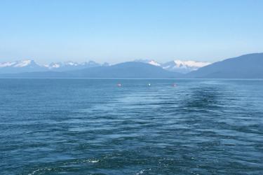 Icy waters in Alaska with mountains in the background