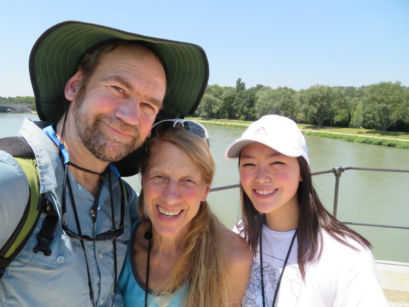 Photo of Pete, Sara and Annie Hagen standing on a bridge with a river in the background.