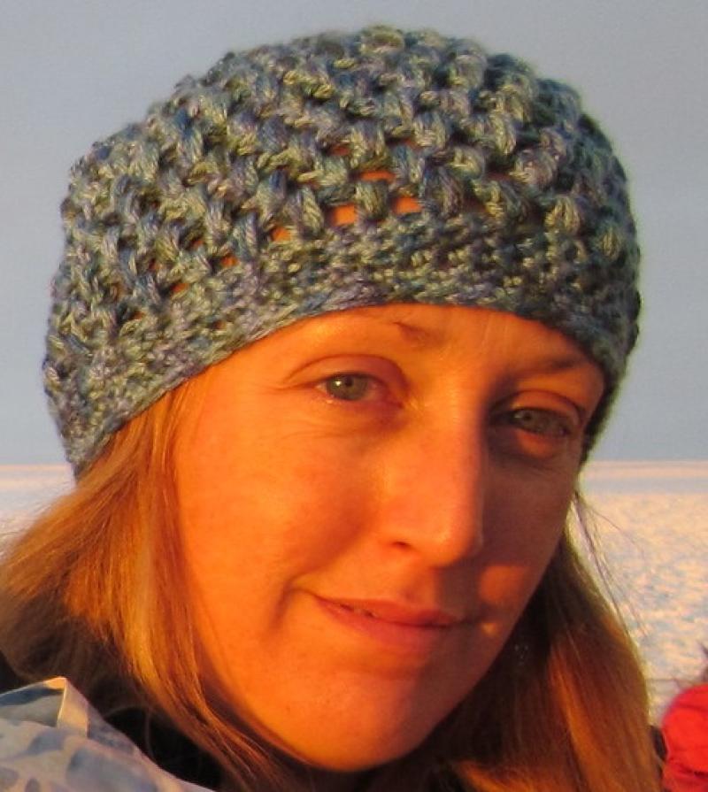 Jen wearing a knit cap with snow in the background