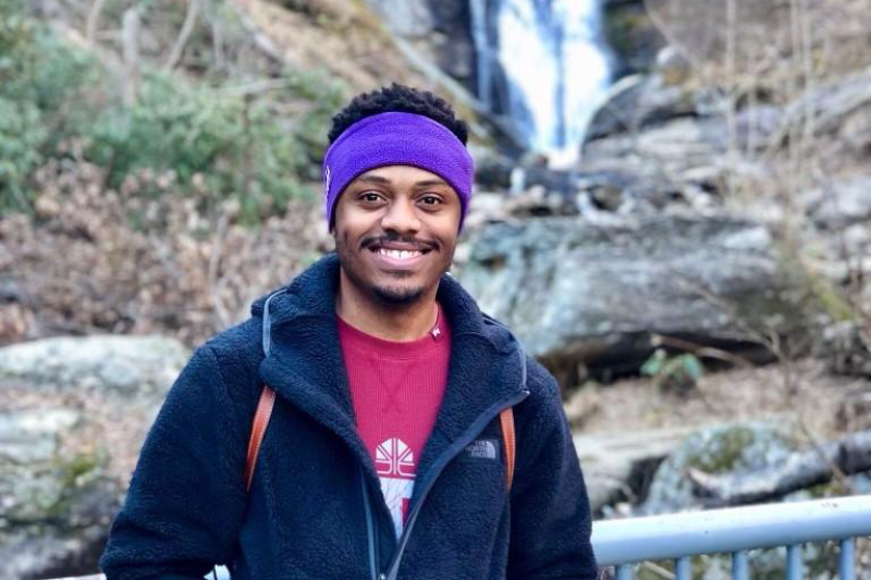 Audy Peoples stops in front of a waterfall while hiking in Asheville, North Carolina