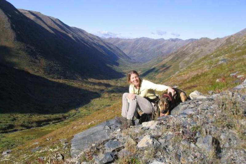 Diane Borggaard on a hill in Alaska with her dog.