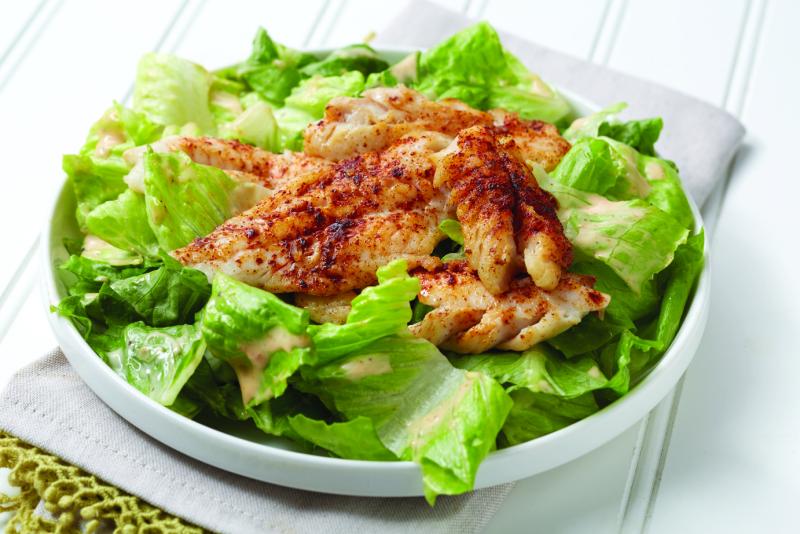 Plate of pollock Caesar salad on a table. 