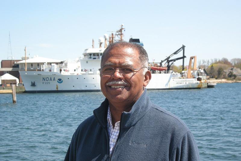 Head and shouldvers view of Ambrose Jearld, Jr., with the 209-foot NOAA Ship Henry B. Bigelow across the harbor at a dock in the background
