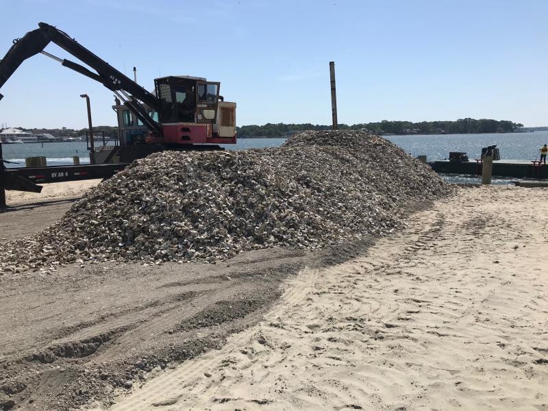 A crane is docked next to a pile of oyster shells