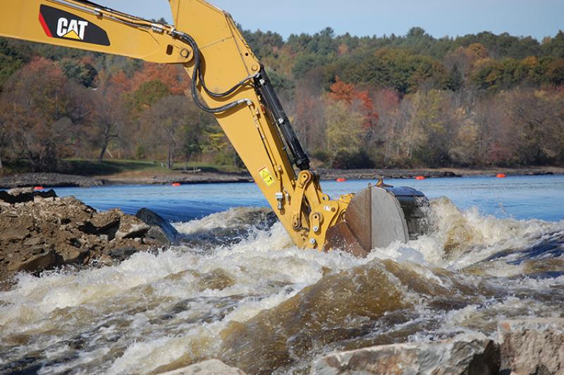 Close up view of an excavator digging in a river