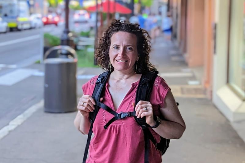 Portrait of a scientist wearing a backpack on a sidewalk in the city