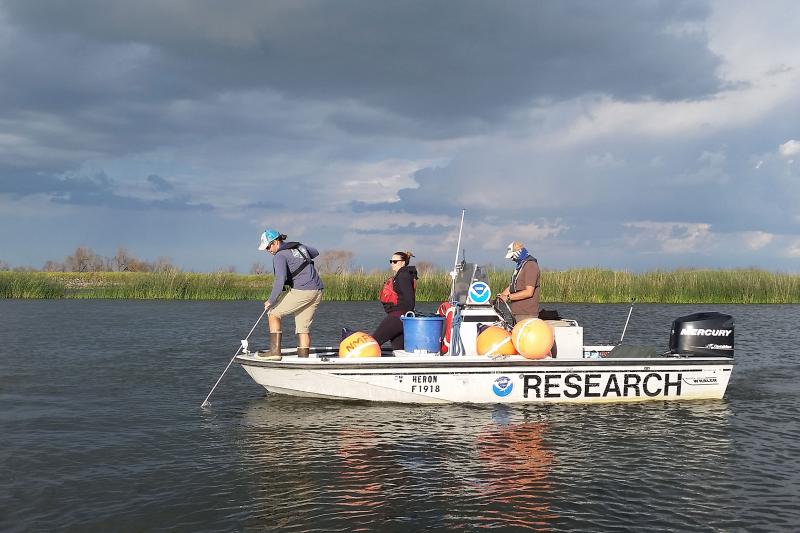 Researchers on a small boat on a river