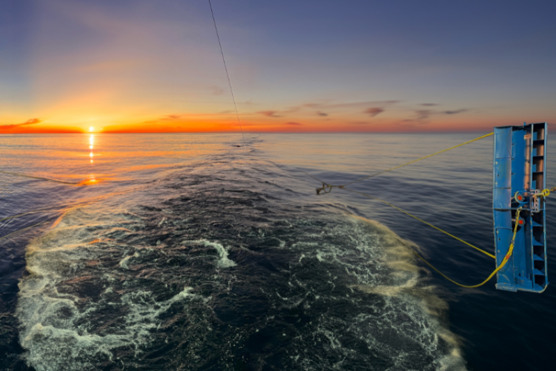 View of MFT net pulled from back of ship with the sun setting in the background